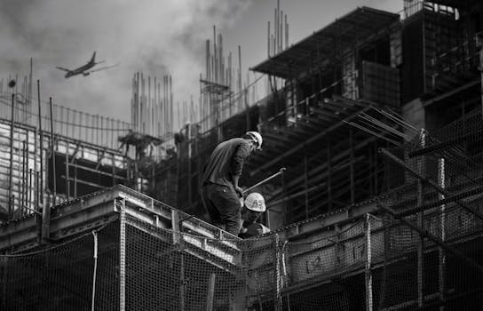 Black and white photo showing construction workers on an urban building site.