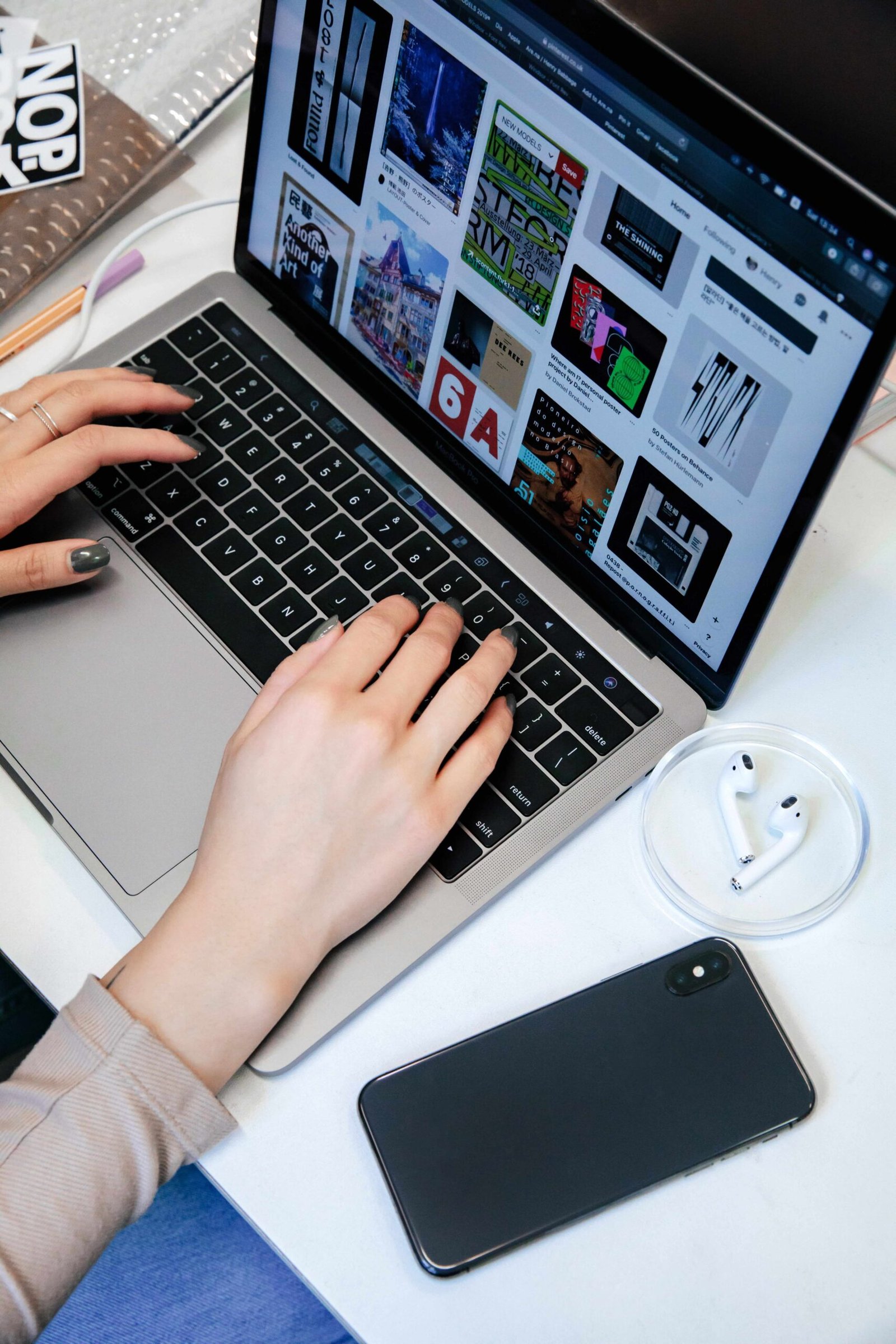 woman typing on laptop, with screen display of images