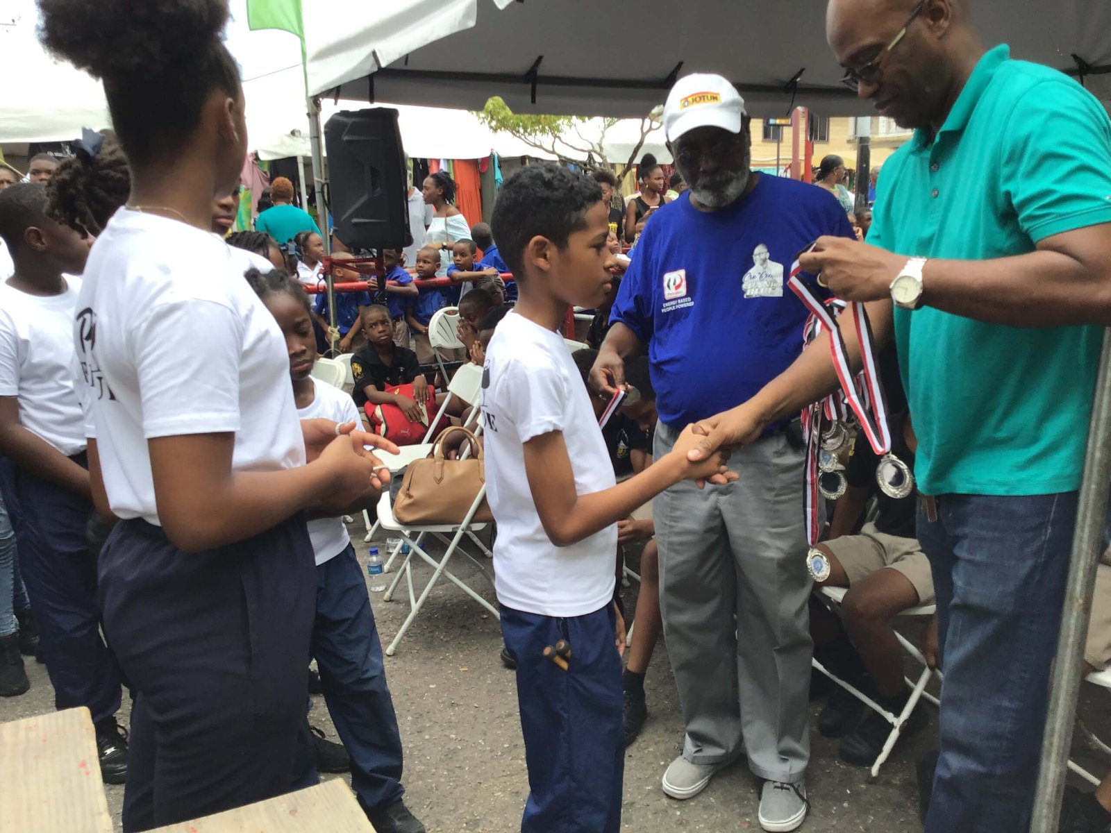 steelband player receiving medal at pan for blue competition