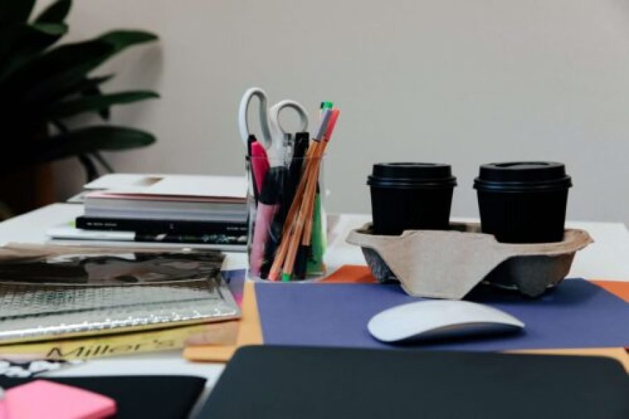 desk with stationary, coffee, mouse and books